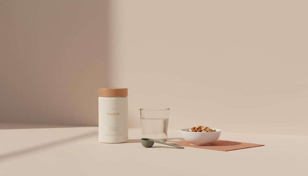 Minimalist kitchen counter still life with Tonum Motus container beside a bowl of measured nuts and a glass of water on a soft beige background—alli vs phentermine