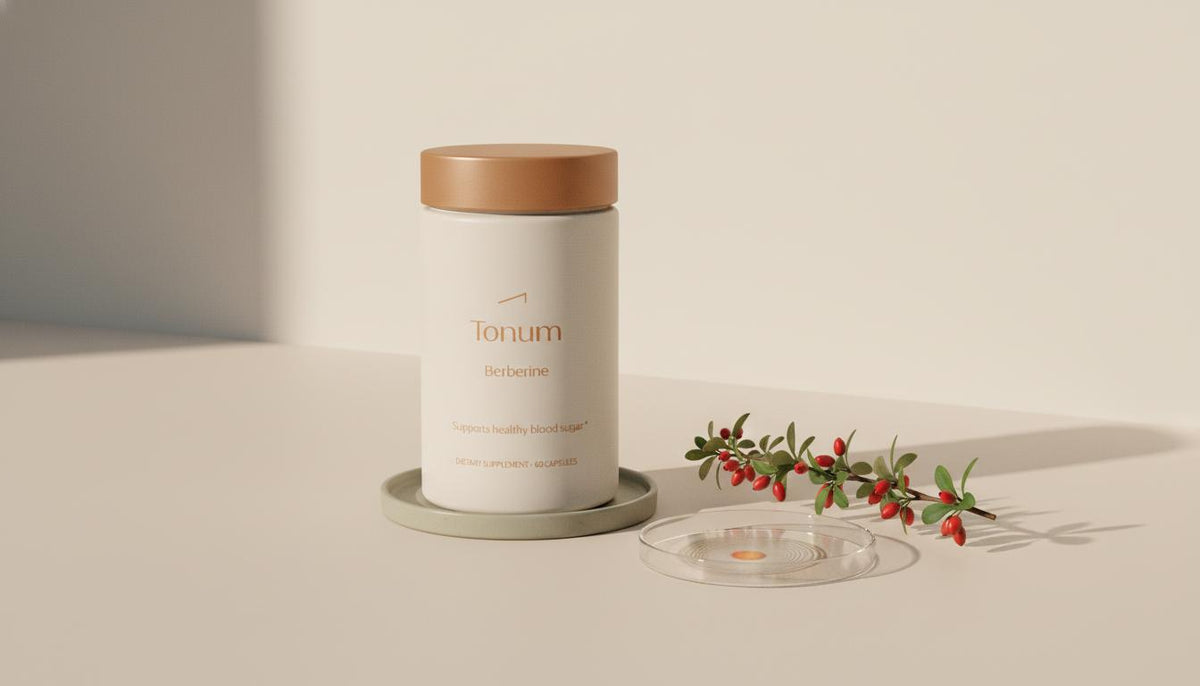 Minimalist still life of a Tonum supplement jar with barberry sprig and Petri dish on a beige background illustrating the benefits of taking berberine supplements