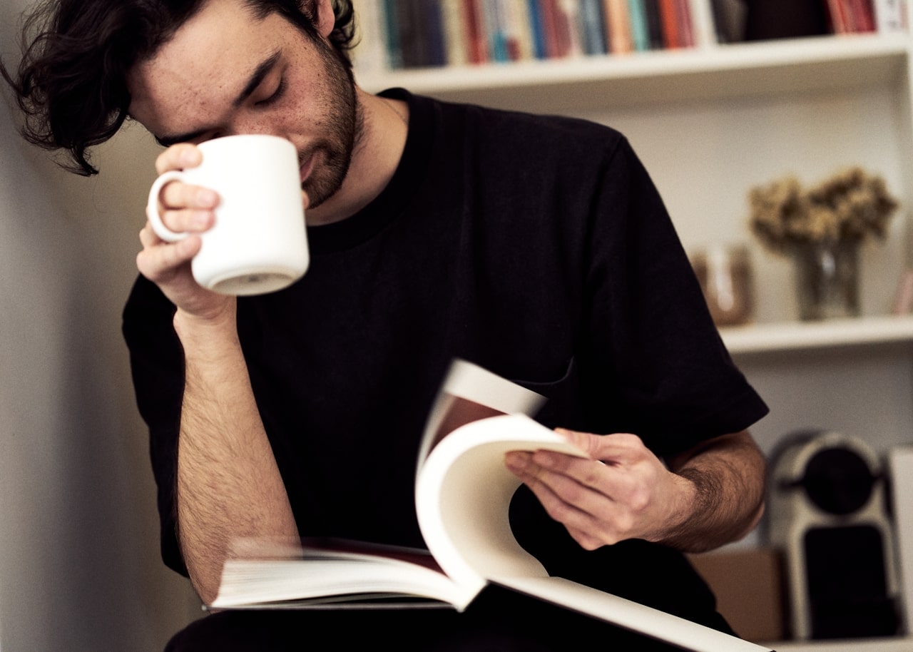 man drinking coffee and reading book to improve cognitive health