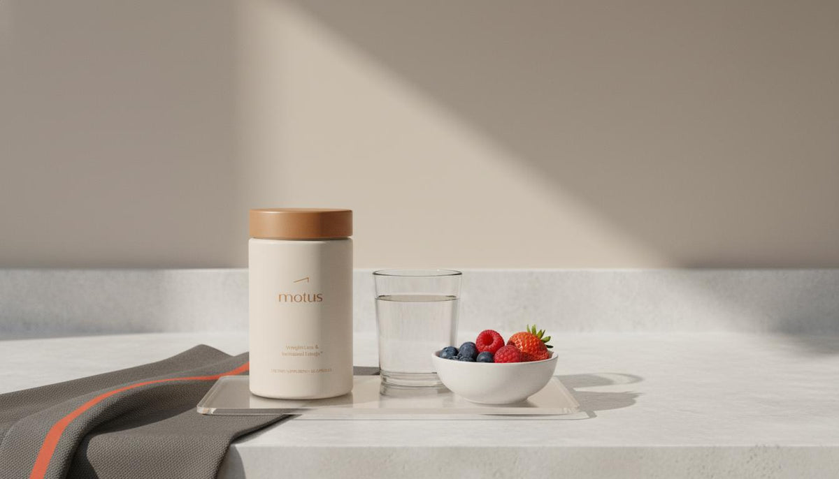 Can losing weight reverse liver disease? Minimalist product photo of Tonum Motus supplement on a neutral kitchen counter with water and a bowl of mixed berries, full-frame.