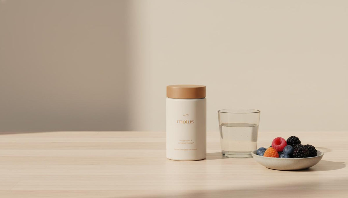 Clean Tonum product shot: Motus container beside a glass of water and a small bowl of mixed berries on a wooden table in a calm, clinical style — does taurine help you lose weight?
