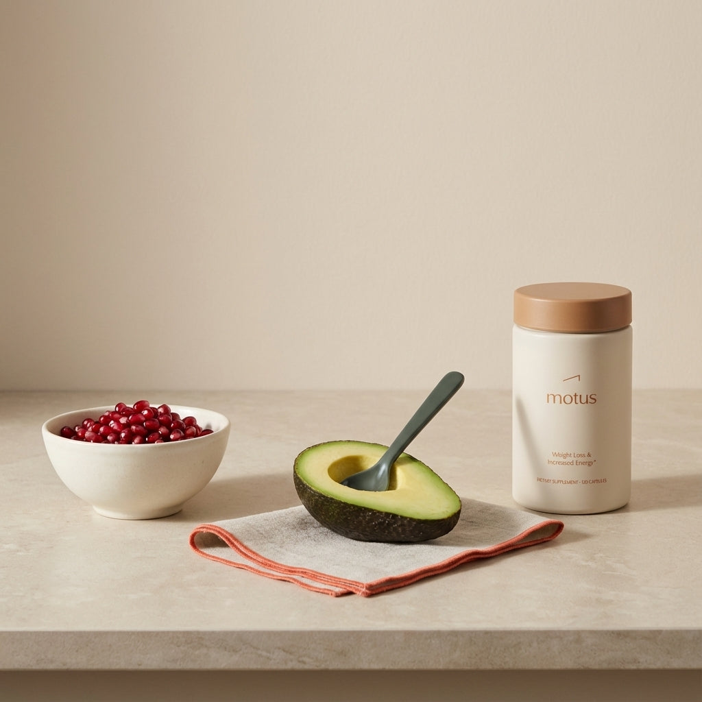 Minimalist kitchen counter with pomegranate arils, halved avocado and Tonum product as a standardized extract vial, illustrating fruits that lower cholesterol.