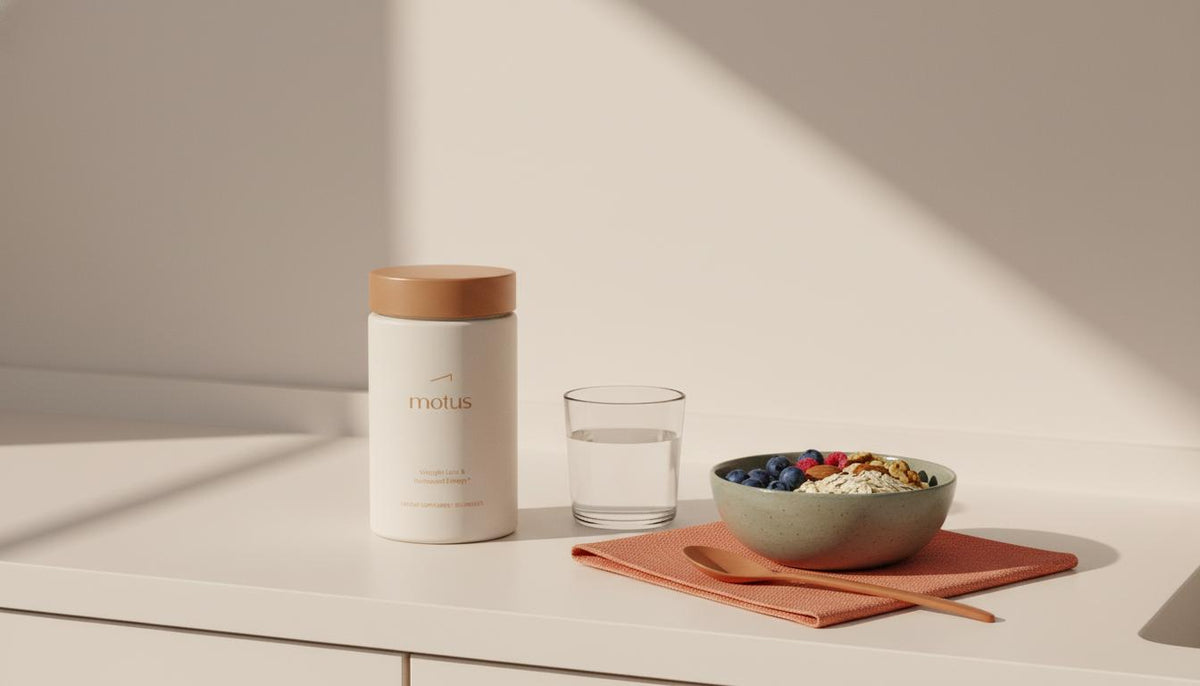 Minimalist kitchen counter with Tonum Motus container beside a bowl of berries, oats and nuts and a glass of water, highlighting hepatic metabolism support.