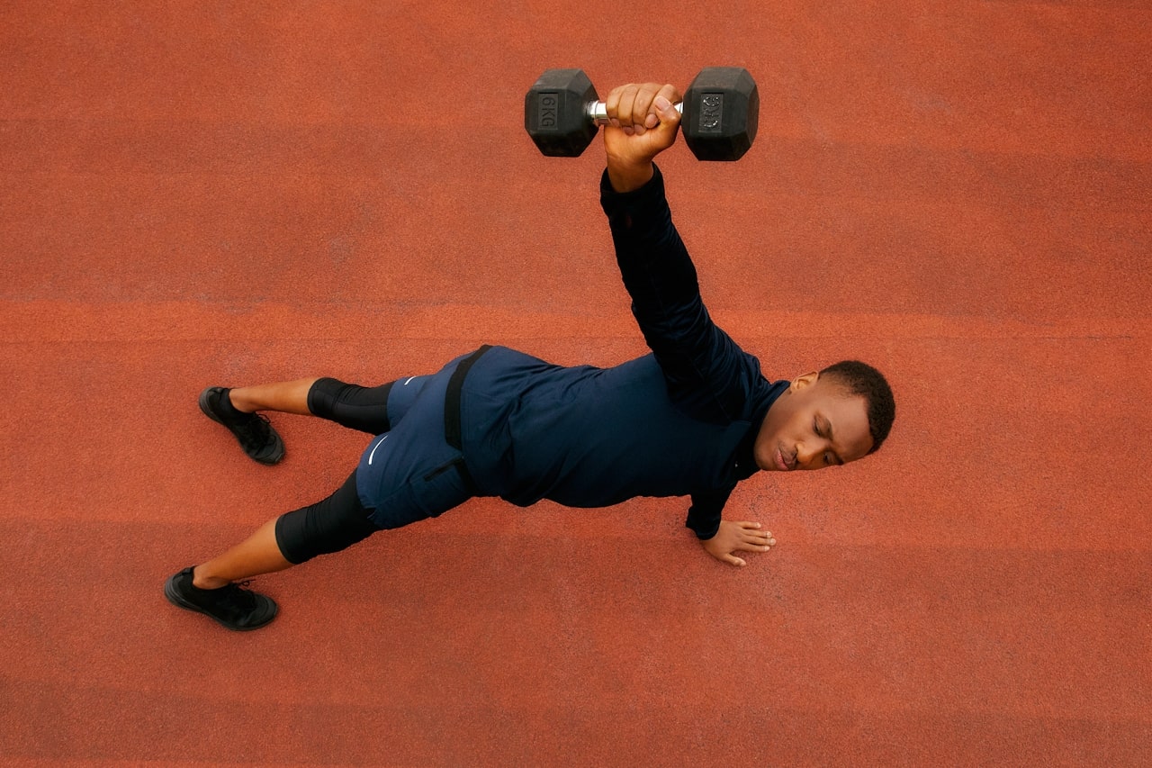 man doing dumbbell exercise on track and field