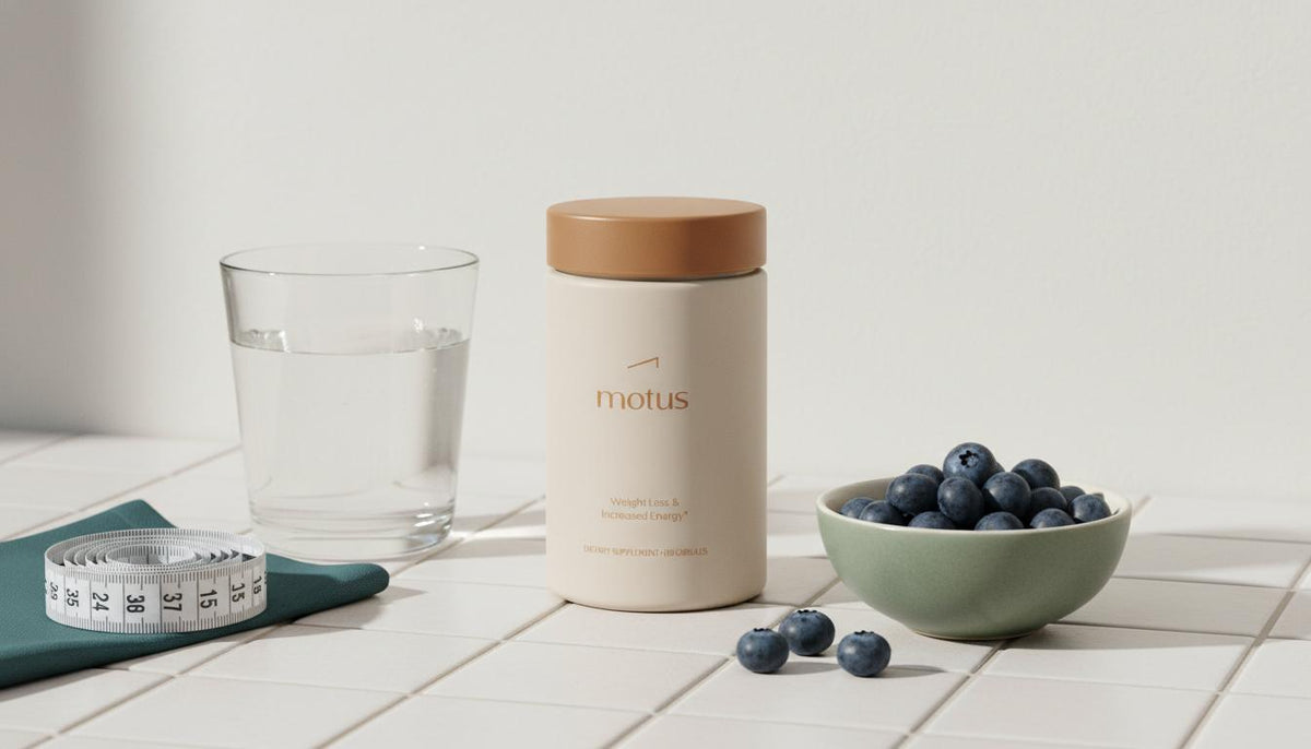 Tonum Motus container on ceramic tile with glass of water, bowl of blueberries and measuring tape in a minimalist health-focused scene — non-prescription weight loss pills.