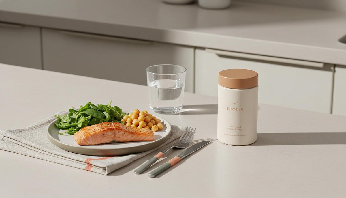 Minimal kitchen counter with Tonum Motus container beside grilled salmon, mixed greens, chickpeas and a glass of water illustrating dietary habits to restore insulin sensitivity